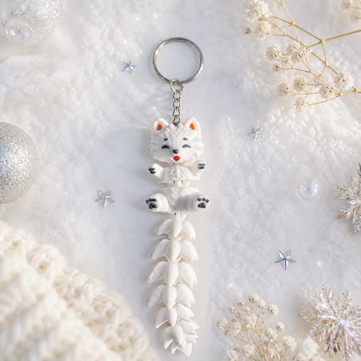 Flexi-Samoyed-Schlüsselanhänger mit Winterschal vor hellem Hintergrund